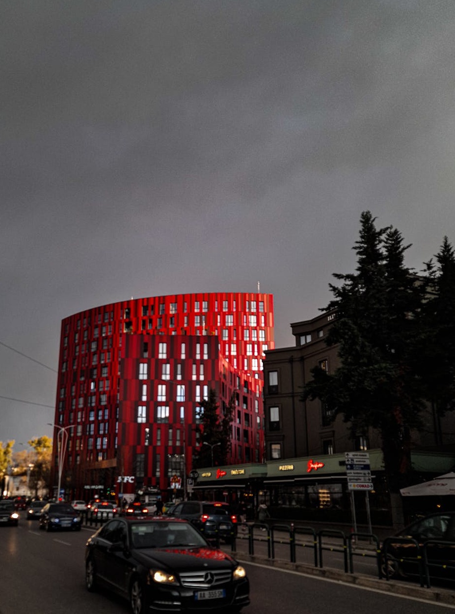 一个人手持智能手机，屏幕上显示YouTube界面的特写，周围有社交媒体点赞图标