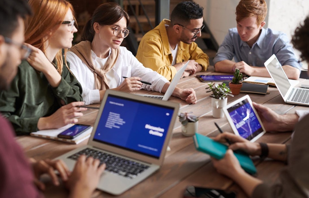 A team collaborating and reviewing options on a screen, representing the careful selection of a Facebook fan provider