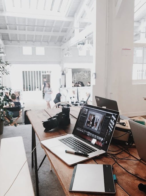 一只手在笔记本电脑旁做出点赞的手势，象征着社会认同和高质量服务