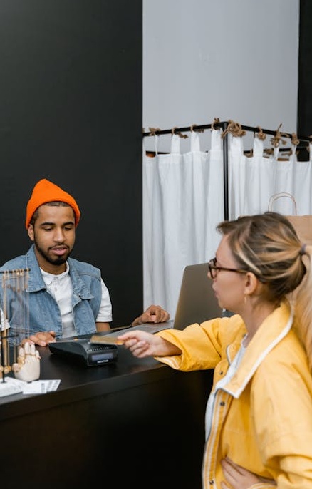 一位时尚博主正在对着镜子自拍，展示她的穿搭，背景有许多衣服