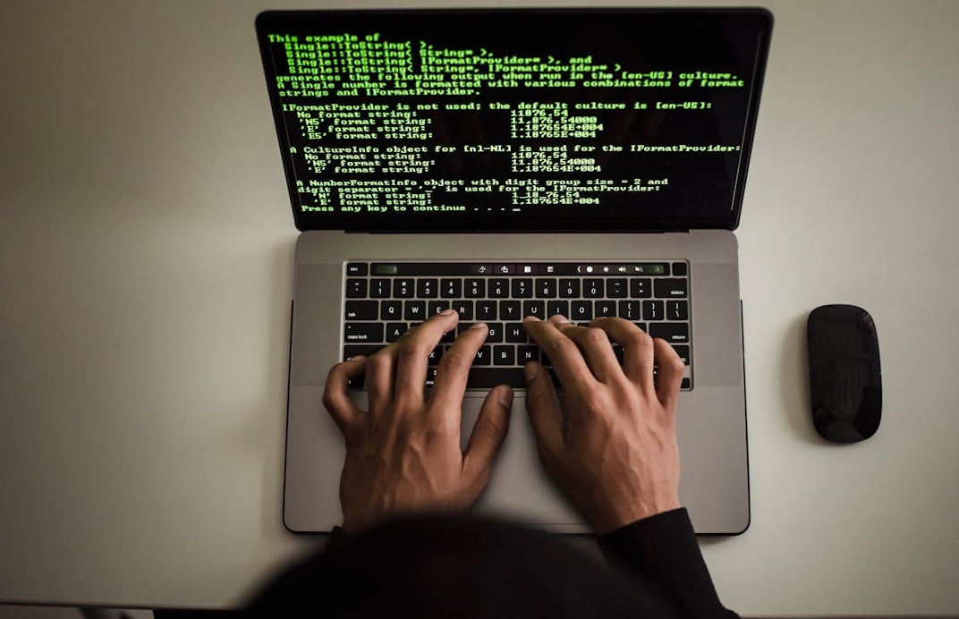 一个人正在分析笔记本电脑上的数据图表