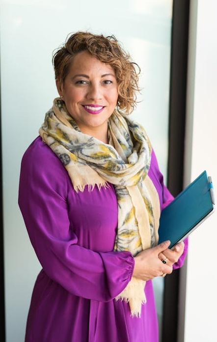 一位女性创业者在咖啡馆里使用笔记本电脑，脸上露出成功的微笑