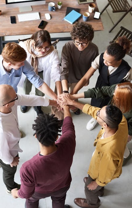 A diverse group of people giving a thumbs up, symbolizing social proof and community approval.