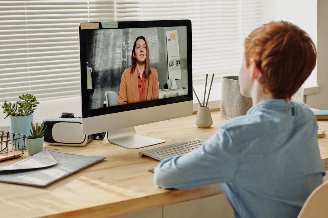 一名女性在家中通过笔记本电脑进行在线学习和操作