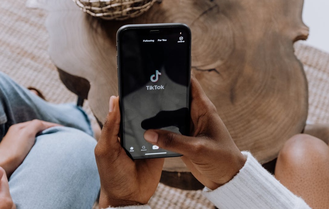 智能手机上显示的TikTok界面，象征着数字互动和社交媒体营销