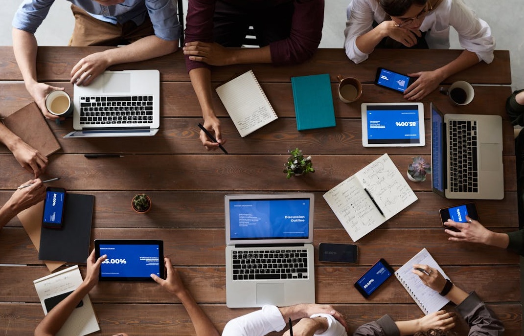 营销团队围绕桌子讨论，将Facebook刷粉策略与内容营销和广告投放相结合