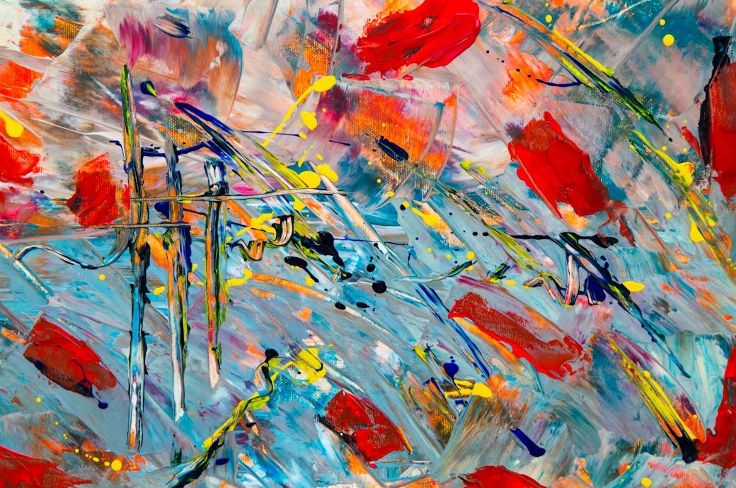 一位艺术家在画室里专心创作，周围摆满了颜料和画笔