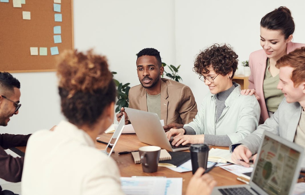 一群人围绕在电脑屏幕前分析数据,代表专业的社交媒体营销服务