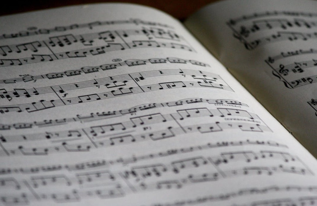 一个男人在昏暗的房间里弹吉他,专注于他的音乐创作