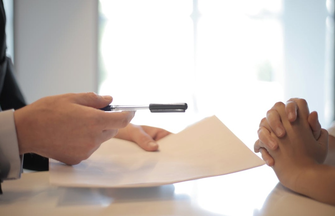 一位穿着商务装的女士自信地微笑,背景是现代化的办公环境