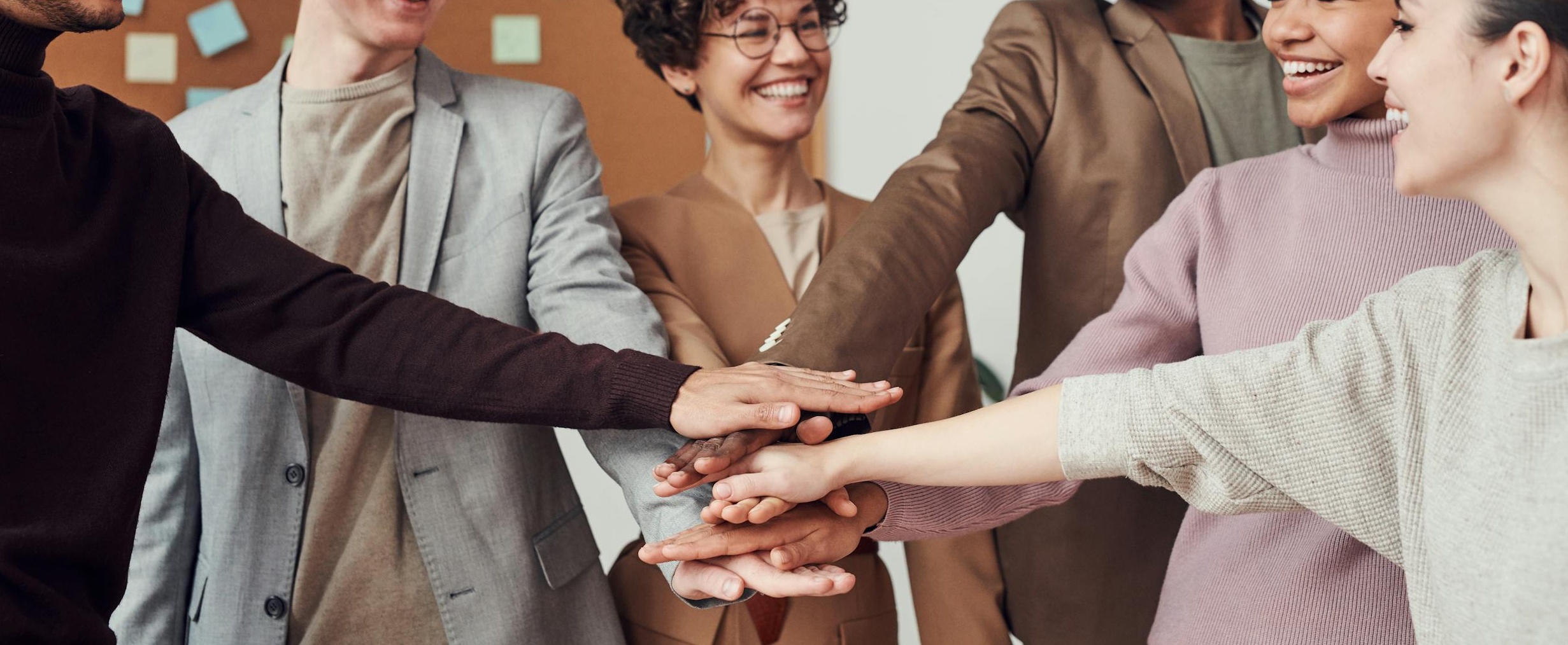 多只手在笔记本电脑前协作,象征社群合作与共同成长