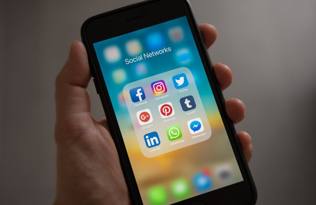 在咖啡店使用笔记本电脑和手机工作的人,暗示数字营销工作