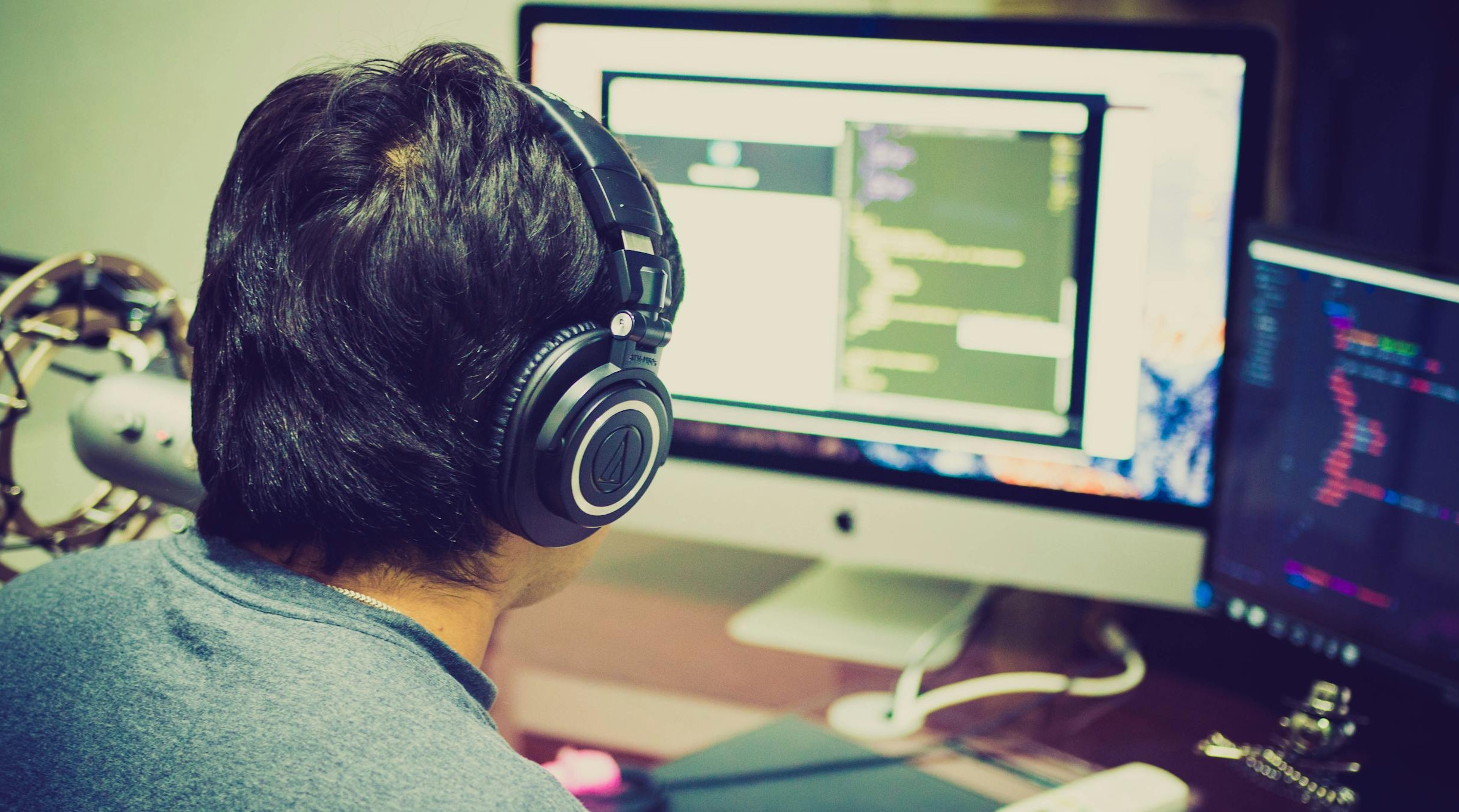 一个人在笔记本电脑前进行创意内容创作,桌面上有相机和纸笔,象征着推特内容推广与创新