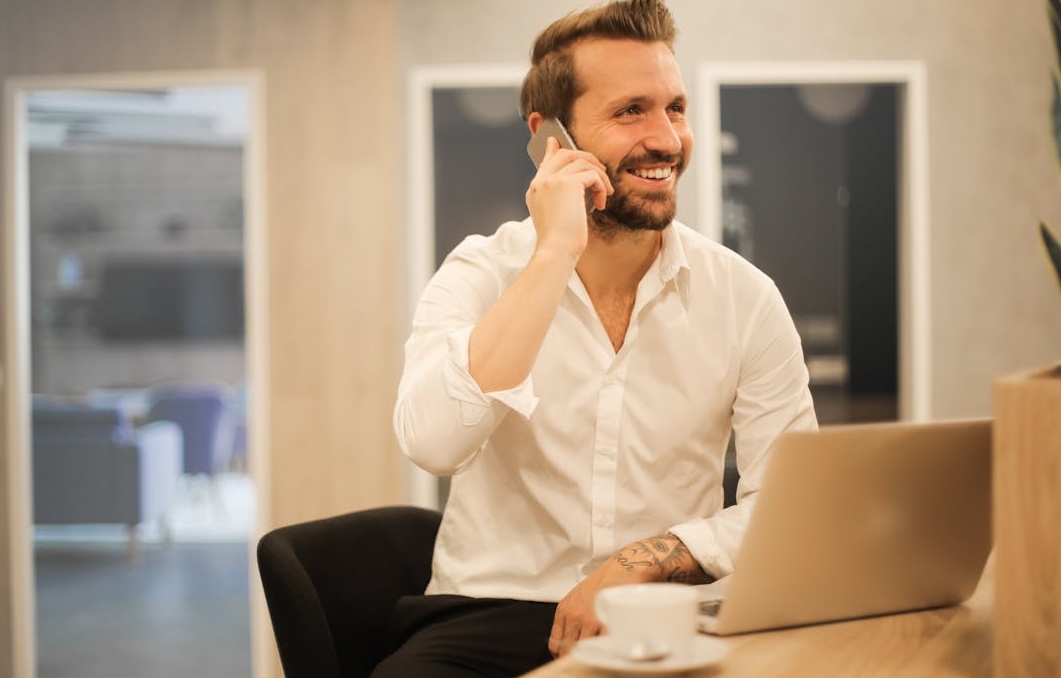 一位客服人员戴着耳机，微笑着通过电脑与客户沟通，象征优质的客户支持与服务。