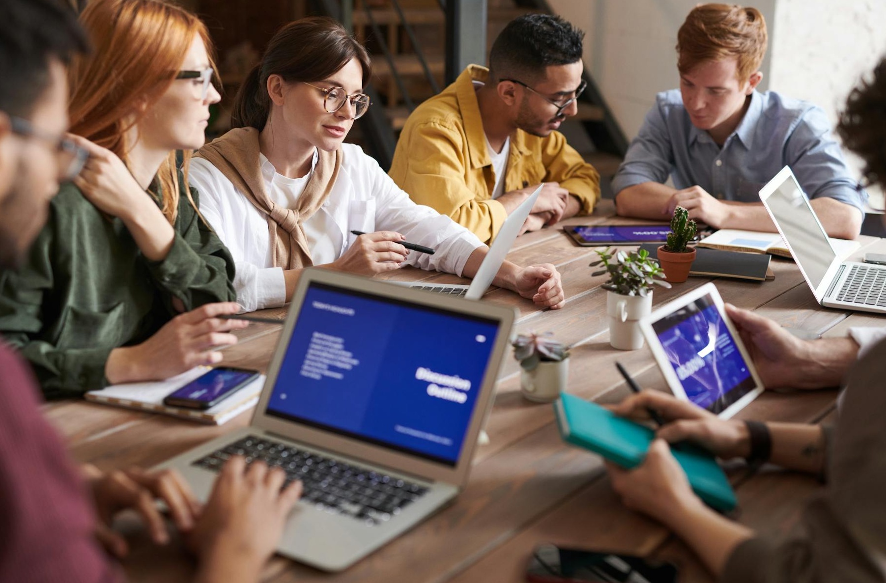 一群人围坐在桌边讨论策略，象征着团队合作和社群管理