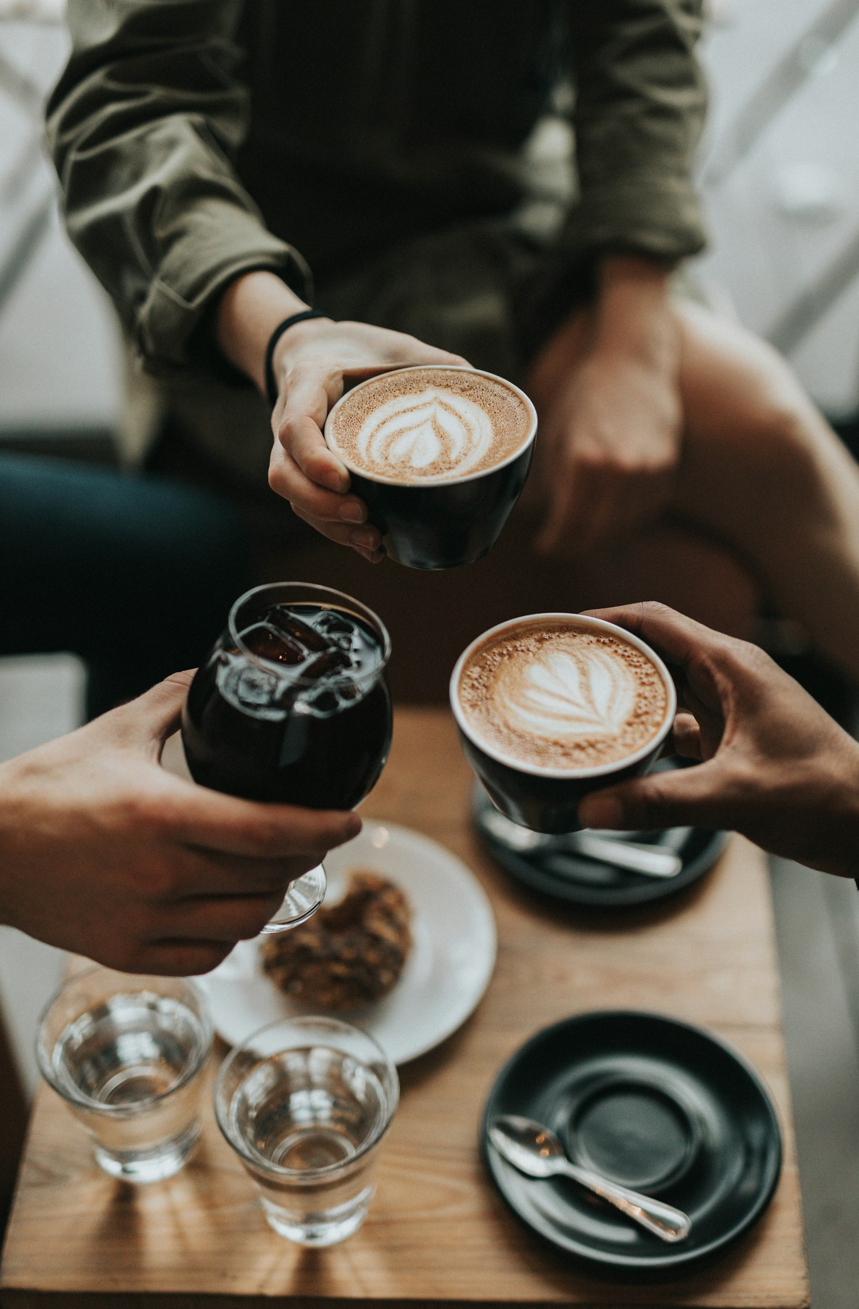 一只手拿着智能手机，屏幕上显示YouTube应用，周围有其他社交媒体应用的图标，代表跨平台推广