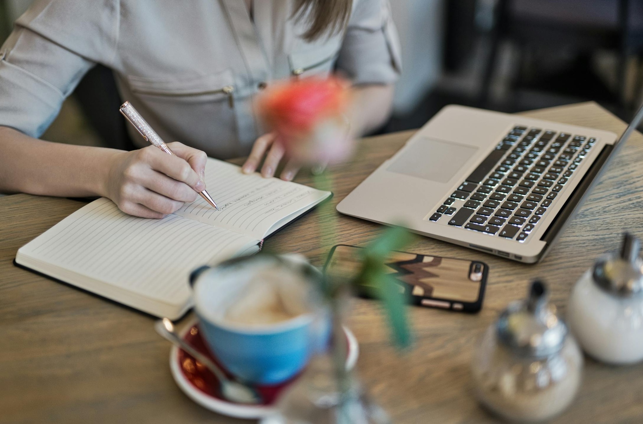 A person writing notes, symbolizing planning and strategy for content creation.