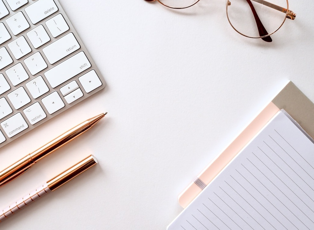 一个创意工作者正在使用笔记本电脑和手机，背景是社交媒体应用的图标，暗示内容创作与传播