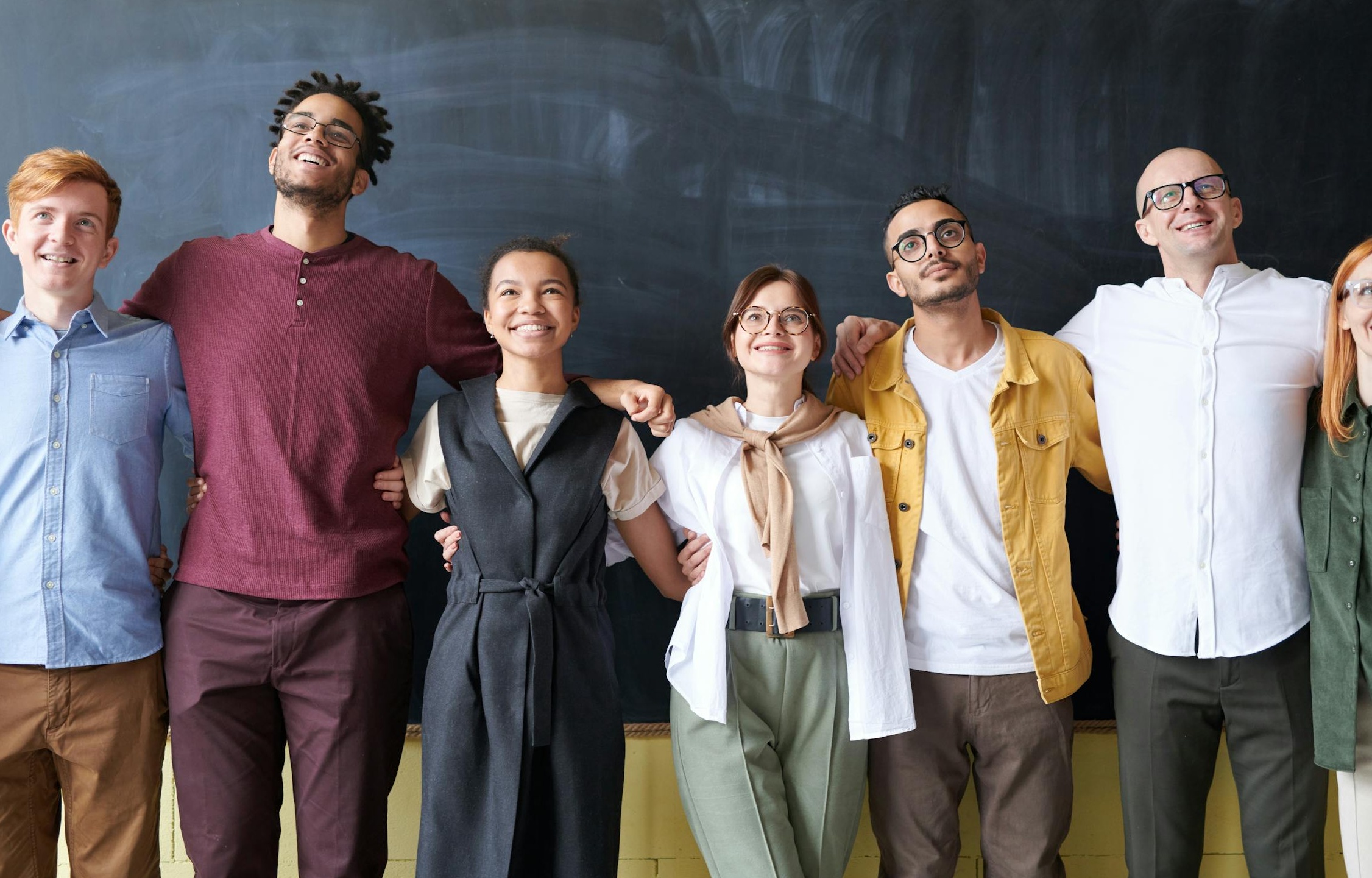 一群人在会议室讨论商业计划，桌上有笔记本电脑和文件